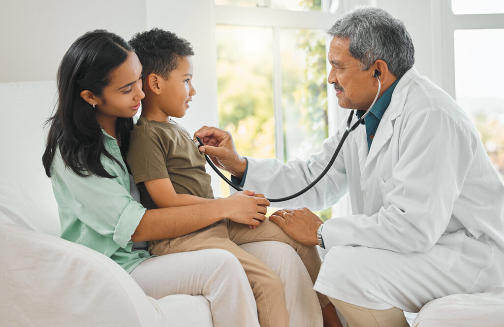 Always listen to your heart. shot of a mature doctor doing a checkup on a little boy at home.